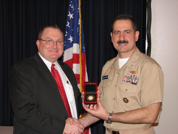 Special Agent Kenneth A. Schmutz (l), FBI, receives a token of appreciation from Cmdr. Paul Anderson, USN, chapter vice president of programs. Schmutz spoke to the general membership about cyberthreats at the March luncheon.